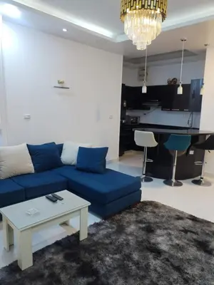 a living room with a blue couch and a table at Al Khaother in Hurghada