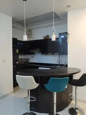a kitchen with a black table and two blue chairs at Al Khaother in Hurghada