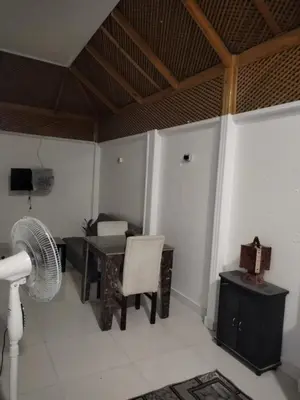 a room with a desk and a table and a fan at Al Khaother in Hurghada