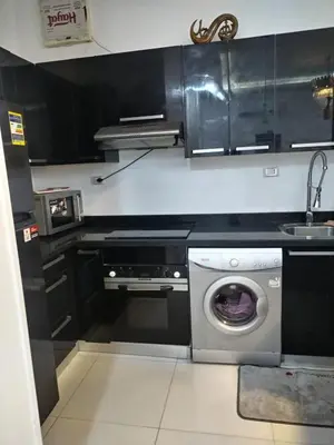 a kitchen with a washing machine and a sink at Al Khaother in Hurghada