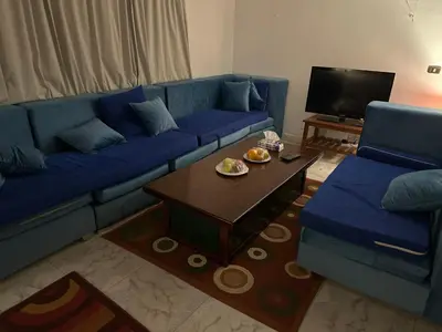 a living room with a blue couch and a coffee table at Paradise Villa Seaview in Hurghada
