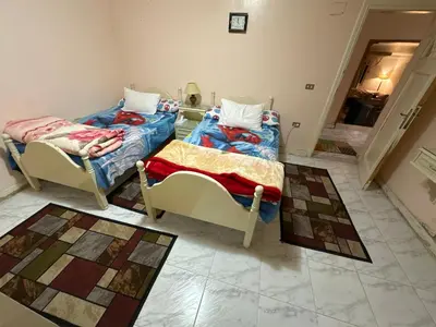 two twin beds in a room with tile floors at Paradise Villa Seaview in Hurghada