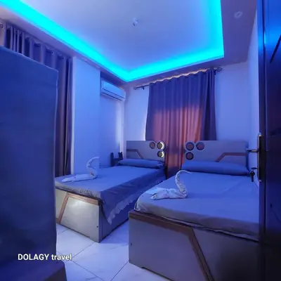 two beds in a room with a blue light at Modern studio in Hurghada