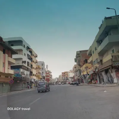 a car driving down a city street with buildings at Modern studio in Hurghada