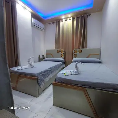 two twin beds in a room with blue lights at Modern studio in Hurghada