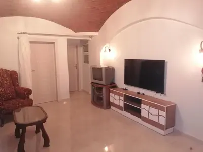 a living room with a television and a chair at 265 Apartment in Hurghada