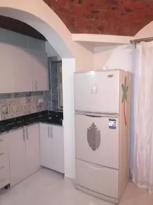 a kitchen with white cabinets and a white refrigerator at 265 Apartment in Hurghada