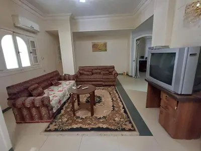 a living room with a couch and a tv at Ahmeds in Luxor