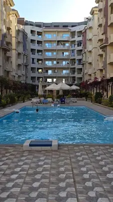 a large swimming pool in front of a building at Florenza Khamsin Lux Apartment in Hurghada
