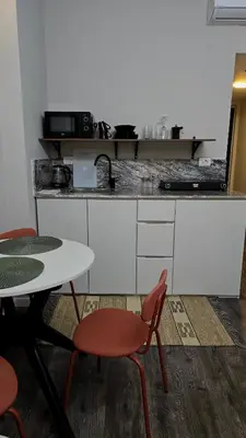 a kitchen with a table and two chairs and a counter at Florenza Khamsin Lux Apartment in Hurghada