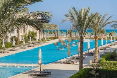 a resort with a pool and palm trees at Neat & Neutral 1BDR Pool front Mangroovy in Hurghada