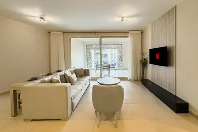 a living room with a couch and a table at Neat & Neutral 1BDR Pool front Mangroovy in Hurghada