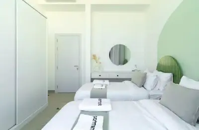 a white living room with a white couch and a mirror at Cozy getaway in El Gouna with pool & mountain view in Hurghada