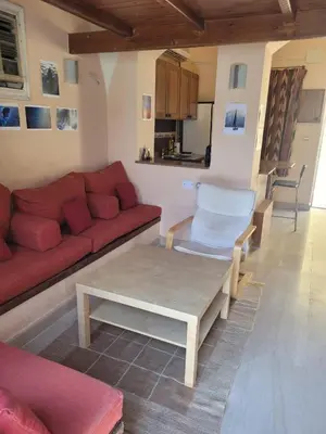 a living room with a red couch and a coffee table at Charming Studio in Downtown El Gouna in Hurghada
