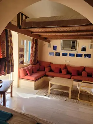 a living room with a red couch and a table at Charming Studio in Downtown El Gouna in Hurghada