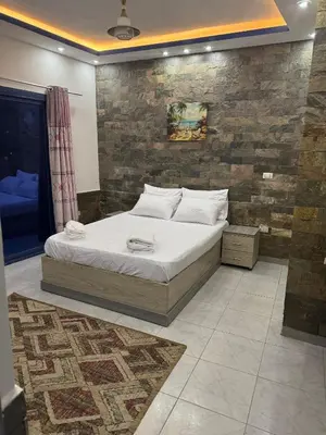 a bed in a room with a brick wall at Modern European Style apartment 1 in Hurghada