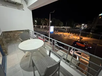 a table and chairs on a balcony at night at Modern European Style apartment 1 in Hurghada