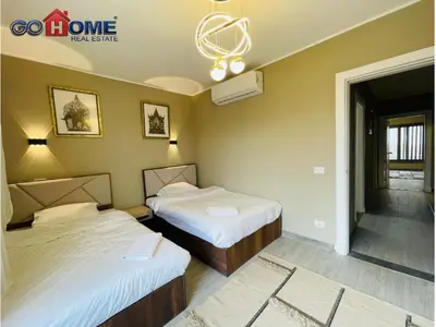 a bedroom with two beds and a chandelier at 3 Bedroom In Bali Heated pool El Gouna in Hurghada