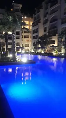 a swimming pool at night with blue lights at Amazing Apartment Aldau Heights in Hurghada