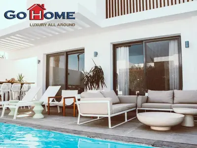 a villa with a swimming pool with white furniture at El Gouna 3 Bedroom in Sholan in Hurghada