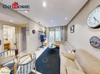 a living room with a couch and a clock on the wall at Mangroovy El-Gouna 1 Bedroom M7 -6B-13 in Hurghada