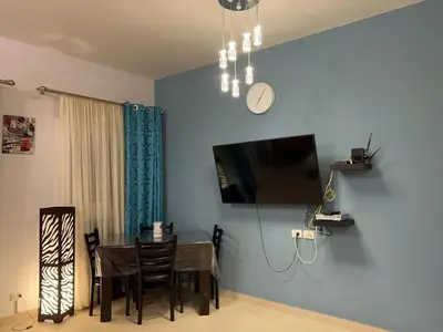 a dining room with a table and a clock on the wall at lovely 2 bedrooms Groundfloor in Hurghada