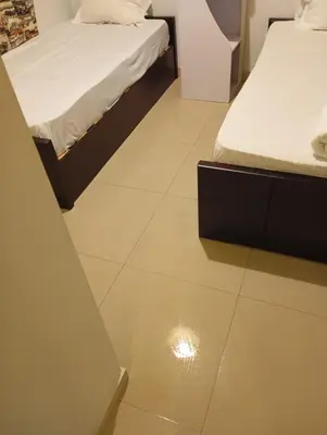 a room with two beds and a tile floor at lovely 2 bedrooms Groundfloor in Hurghada