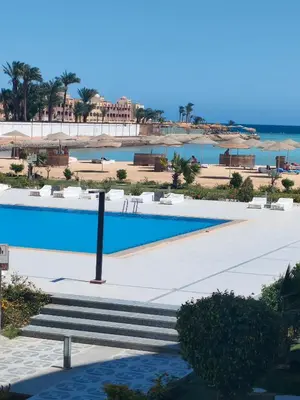 a swimming pool with a beach in the background at Scandic Resort in Hurghada