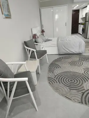 a bedroom with a bed and a chair and a rug at Scandic Resort in Hurghada