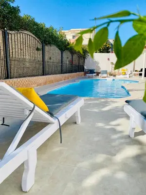a white bench next to a swimming pool at Magawish Hurghada Studio 7 in Hurghada