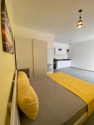 a bedroom with a large bed with a yellow pillow at Magawish Hurghada Studio 7 in Hurghada