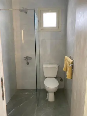 a bathroom with a toilet and a glass shower at Magawish Hurghada Studio 7 in Hurghada