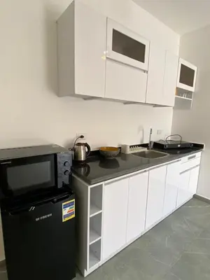 a kitchen with a microwave and a black refrigerator at Magawish Hurghada Studio 7 in Hurghada