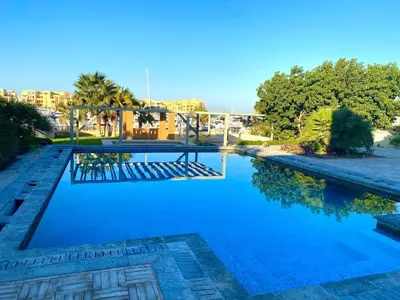 a swimming pool with blue water and a bridge at Abu Tig Marnia El Gouna MB04 in Hurghada