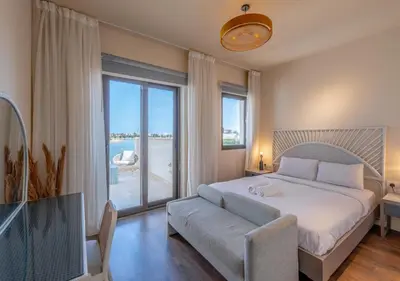 a bedroom with a bed and a couch and a large window at 4BR Cyan Dream Villa I Pool Lagoon & Sauna in Hurghada