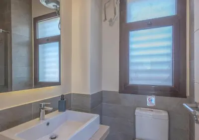 a bathroom with a sink and a toilet and a window at 4BR Cyan Dream Villa I Pool Lagoon & Sauna in Hurghada