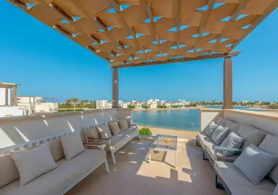 a patio with couches and a view of the water at 4BR Cyan Dream Villa I Pool Lagoon & Sauna in Hurghada