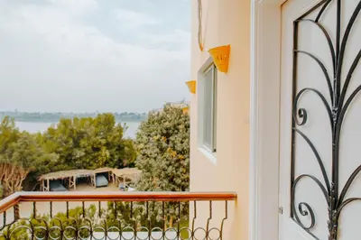 a balcony with a view of the water at Aton Suites Luxor Resort East Bank Nile View in Luxor