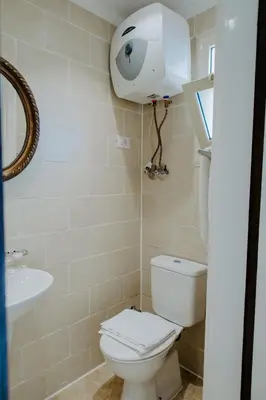 a bathroom with a toilet and a sink at Aton Suites Luxor Resort East Bank Nile View in Luxor