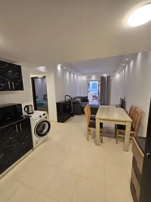 a kitchen and living room with a table and a couch at Florenza Khamsin in Hurghada