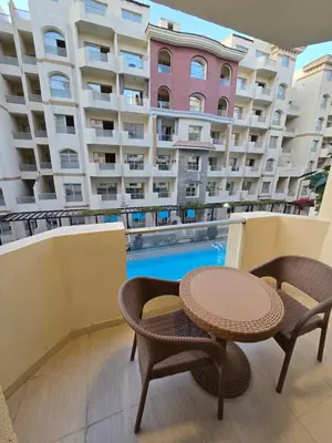 a balcony with a table and chairs and a building at Florenza Khamsin in Hurghada