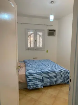 a bedroom with a bed with a blue and white blanket at Tala 1 in Hurghada