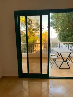 a sliding glass door with a table on a balcony at Tala 1 in Hurghada