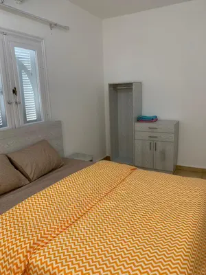 a bedroom with a bed with an orange and white comforter at Tala 1 in Hurghada
