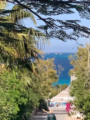 a man walking down a street next to the ocean at Tala 1 in Hurghada