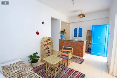 a living room with a table and a chair at Isis Club House in ‘Ezbet Abu Ḥabashi