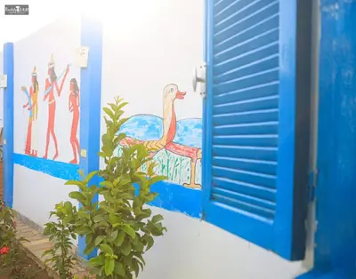 a blue door with a painting of a bird on it at Isis Club House in ‘Ezbet Abu Ḥabashi
