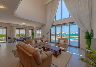 a living room with couches and chairs and a pool at Ancient Sands Gouna 4BR Villa Heated Pool & Lagoon in Hurghada