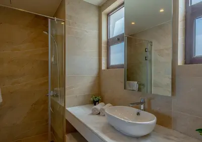 a bathroom with a sink and a glass shower at Ancient Sands Gouna 4BR Villa Heated Pool & Lagoon in Hurghada