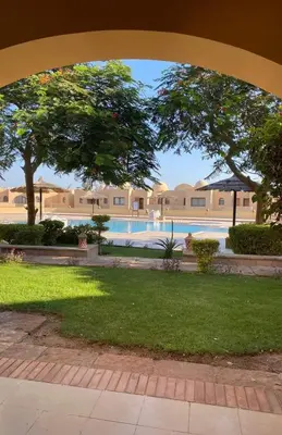 a view of a swimming pool from an archway at Doplex for rent in the view 18 in Hurghada